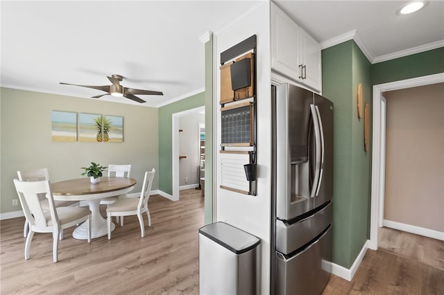 kitchen featuring ornamental molding, stainless steel refrigerator with ice dispenser, light wood-style flooring, and white cabinetry