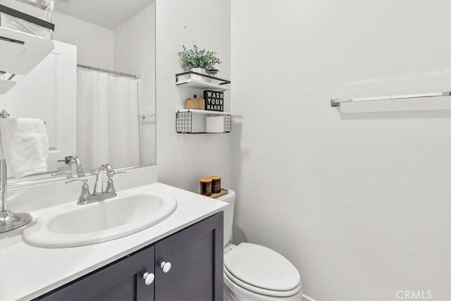 bathroom featuring toilet, a shower with shower curtain, and vanity