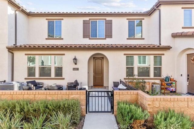 view of front of home with a fenced front yard, a gate, central AC unit, and stucco siding