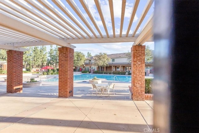 view of patio with a community pool and a pergola