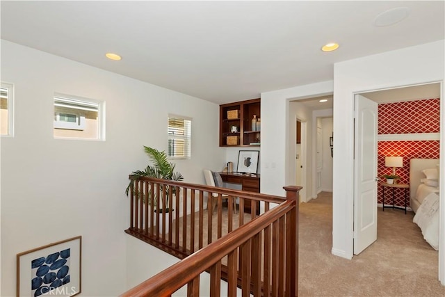 hallway with light carpet, recessed lighting, and an upstairs landing