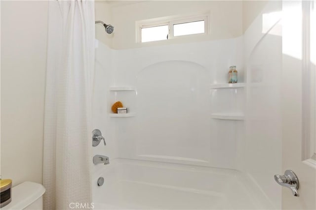 bathroom featuring shower / bath combination with curtain and toilet