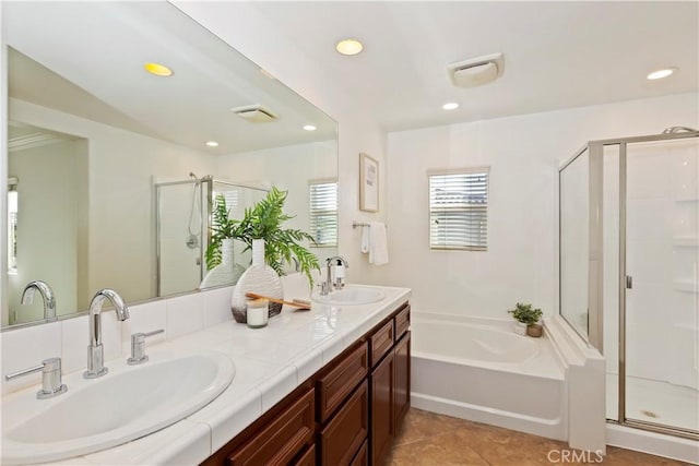 bathroom with a garden tub, a shower stall, a sink, and recessed lighting