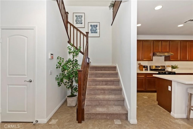 staircase featuring baseboards, tile patterned floors, visible vents, and recessed lighting