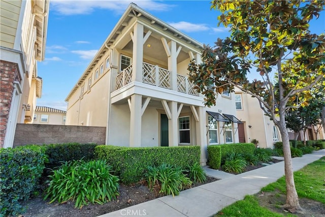 view of front of house with a balcony and stucco siding