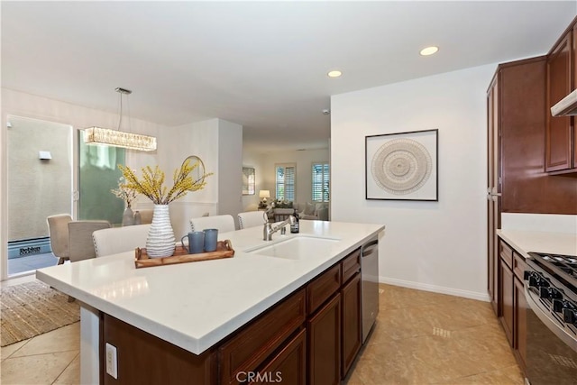 kitchen with a sink, light countertops, dishwasher, gas range oven, and an island with sink