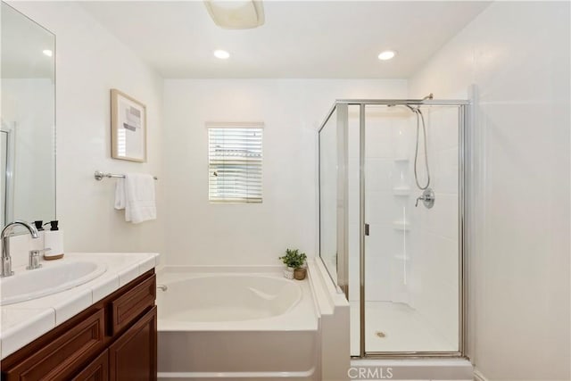 bathroom with vanity, a shower stall, a bath, and recessed lighting