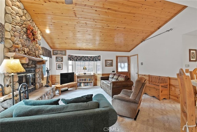 carpeted living area featuring wooden ceiling, a fireplace, high vaulted ceiling, and a wainscoted wall