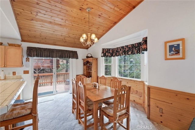 dining room with a healthy amount of sunlight, an inviting chandelier, wood ceiling, and light colored carpet