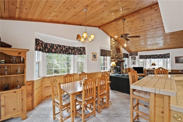 dining room featuring lofted ceiling, wooden ceiling, light carpet, and a healthy amount of sunlight