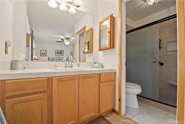 full bath featuring toilet, a ceiling fan, a stall shower, vanity, and tile patterned flooring