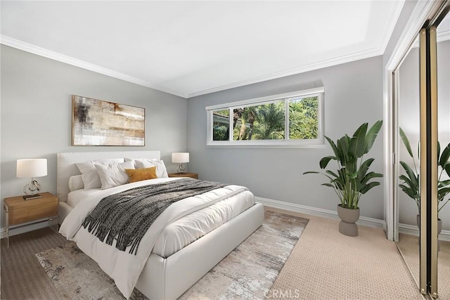 carpeted bedroom with a baseboard radiator, crown molding, and baseboards