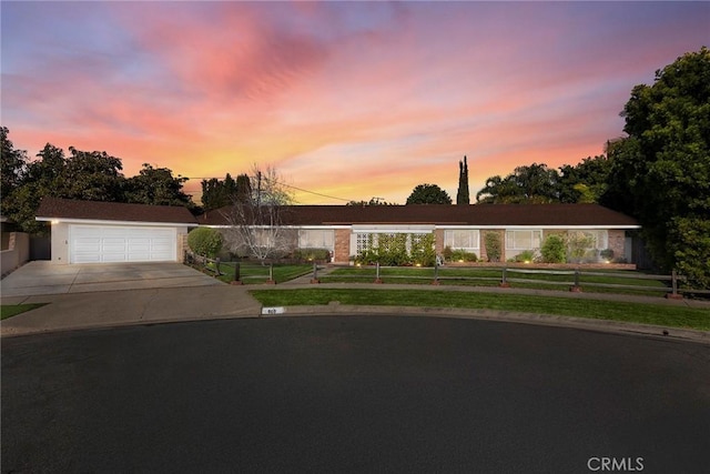 ranch-style home with a garage, a lawn, and fence