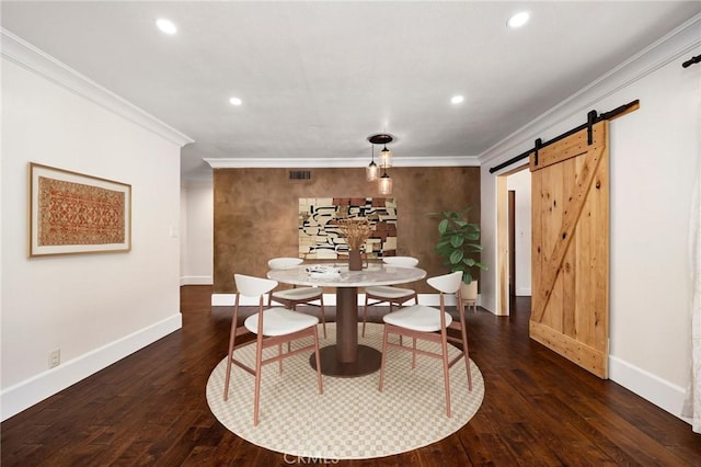 dining space featuring ornamental molding, wood finished floors, baseboards, and a barn door