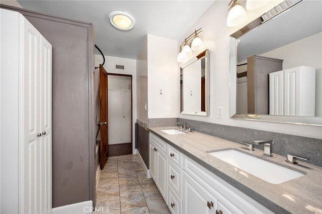 full bathroom featuring double vanity, a sink, and visible vents