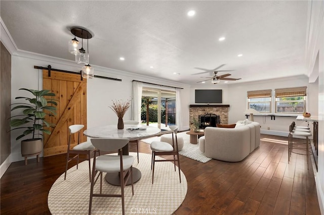 living room with a barn door, crown molding, and dark wood-type flooring