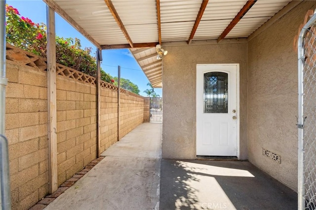 property entrance with crawl space, fence, and stucco siding