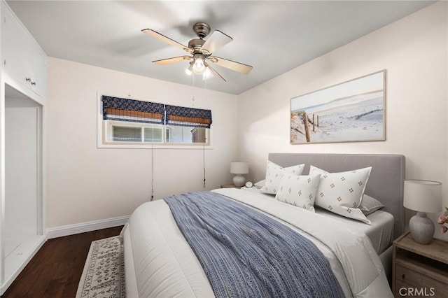 bedroom featuring dark wood-style floors, baseboards, and a ceiling fan