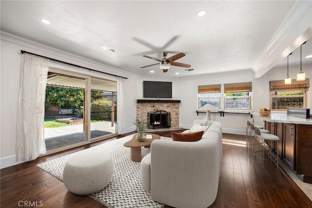 living room with dark wood-style floors, a healthy amount of sunlight, and crown molding