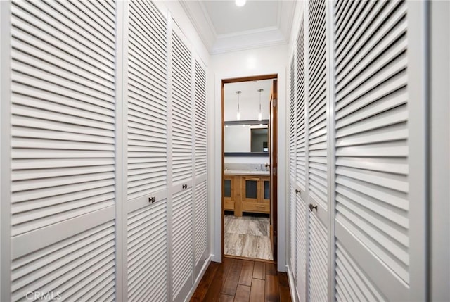 hall featuring ornamental molding and dark wood-style flooring