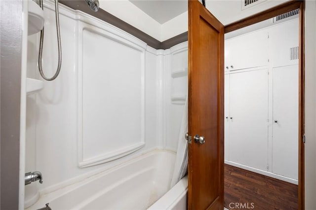 full bathroom with visible vents, bathing tub / shower combination, and wood finished floors