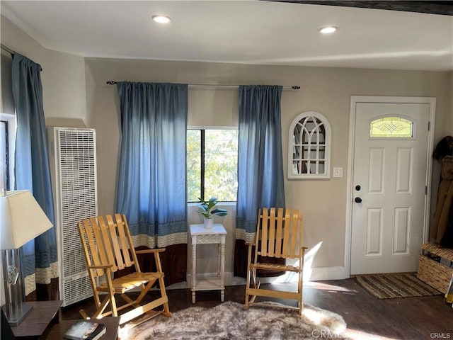 living area featuring baseboards, a heating unit, wood finished floors, and recessed lighting