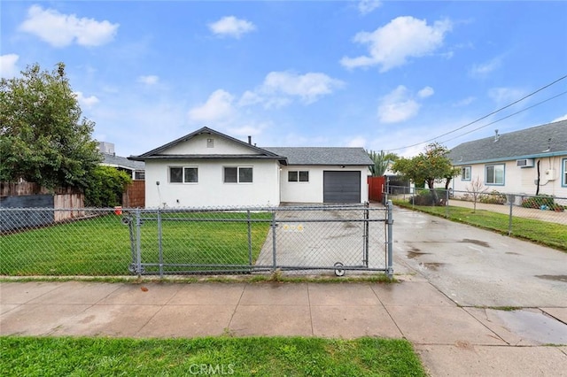 view of front facade with a fenced front yard, driveway, a front lawn, and stucco siding