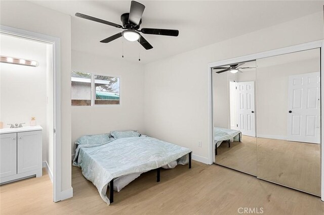 bedroom with baseboards, ceiling fan, ensuite bath, and light wood finished floors