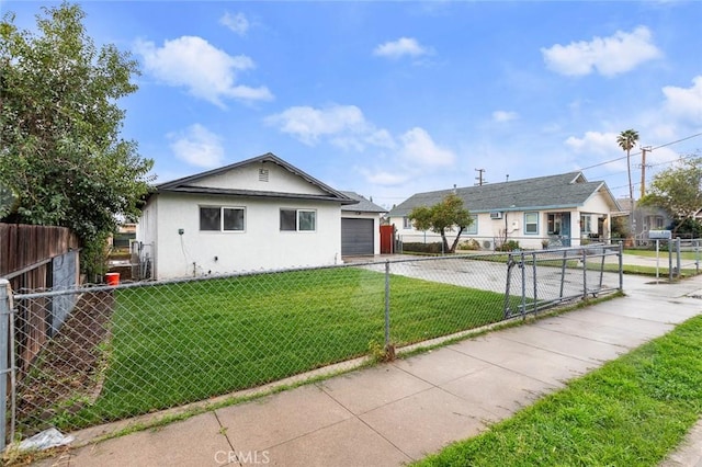 view of front of house featuring a fenced front yard, concrete driveway, a front lawn, and stucco siding