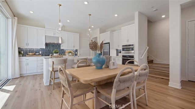 dining room with stairway, recessed lighting, light wood-style flooring, and baseboards