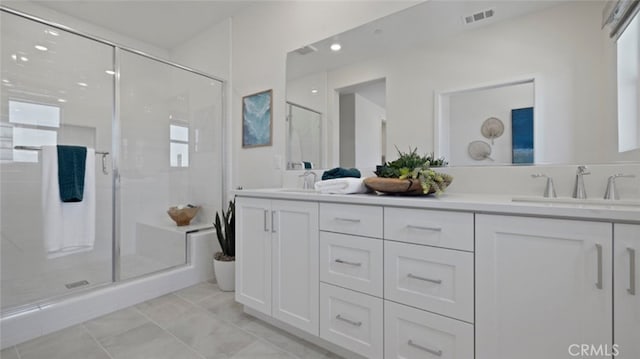 bathroom with a stall shower, visible vents, a sink, and double vanity