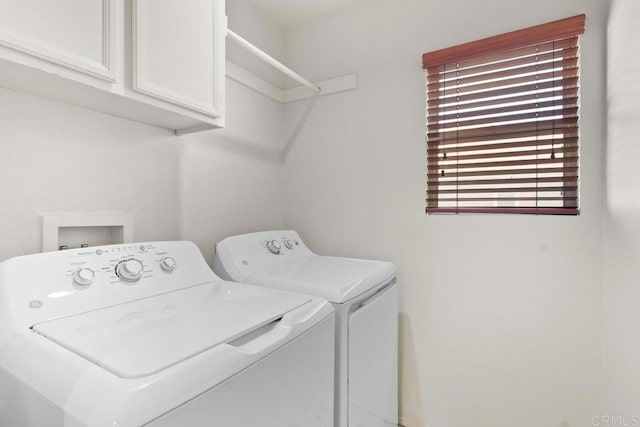 laundry room with independent washer and dryer and cabinet space