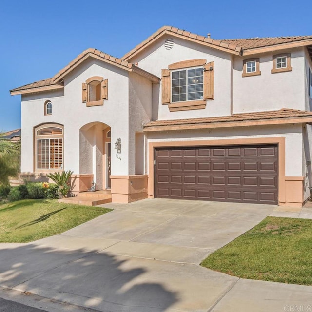 mediterranean / spanish-style house featuring a garage, concrete driveway, a tile roof, and stucco siding