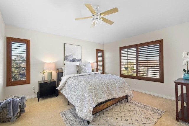 bedroom with light carpet, ceiling fan, and baseboards