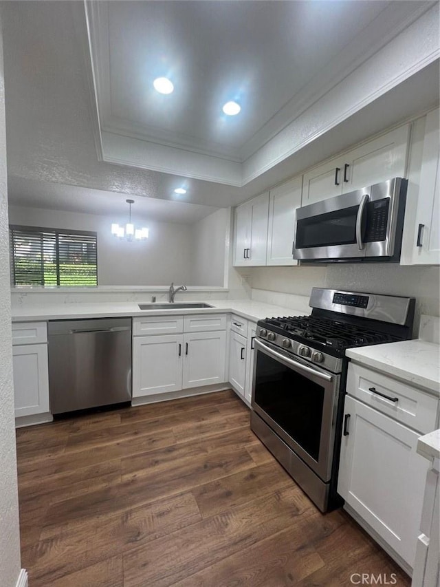 25614 Mont Pointe Unit 3D, Lake Forest, CA 92630 - kitchen featuring appliances with stainless steel finishes, crown molding, a chandelier, white cabinets, and dark wood finished floors