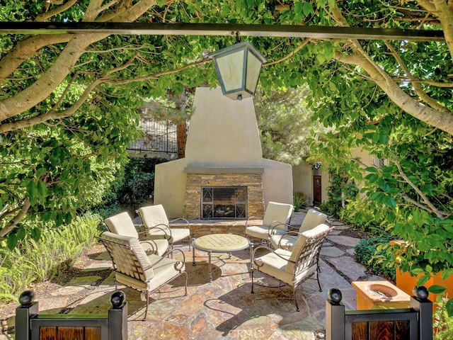 view of patio with an outdoor stone fireplace