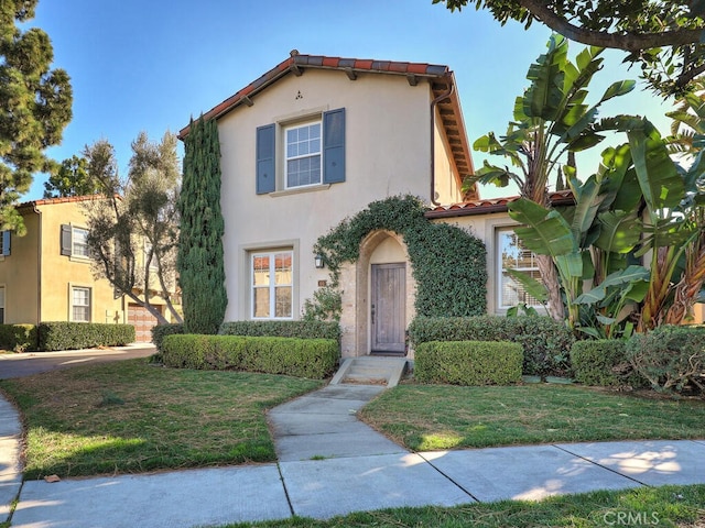 mediterranean / spanish-style house with a front yard and stucco siding