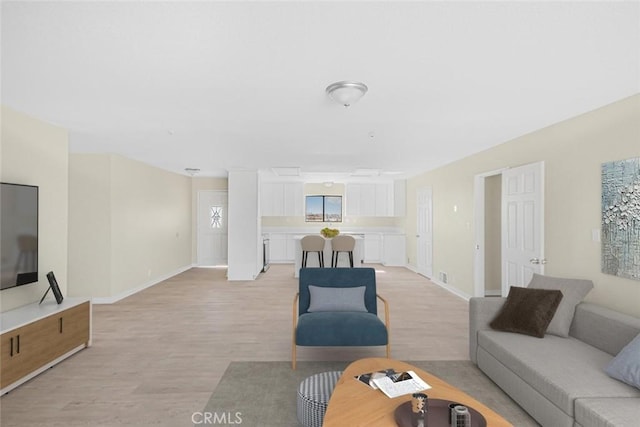 living area with light wood-type flooring and baseboards