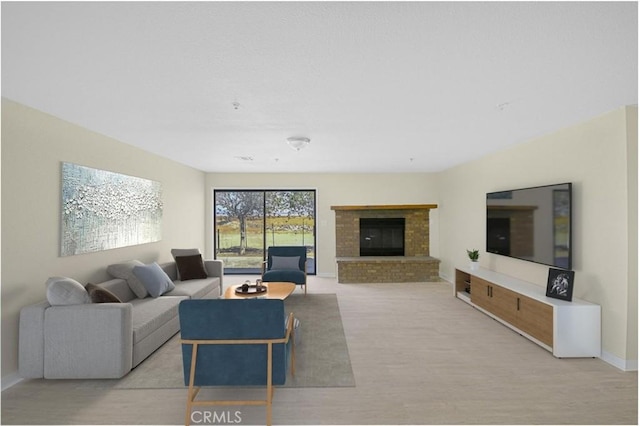 living area featuring baseboards, a fireplace, and light wood-style floors