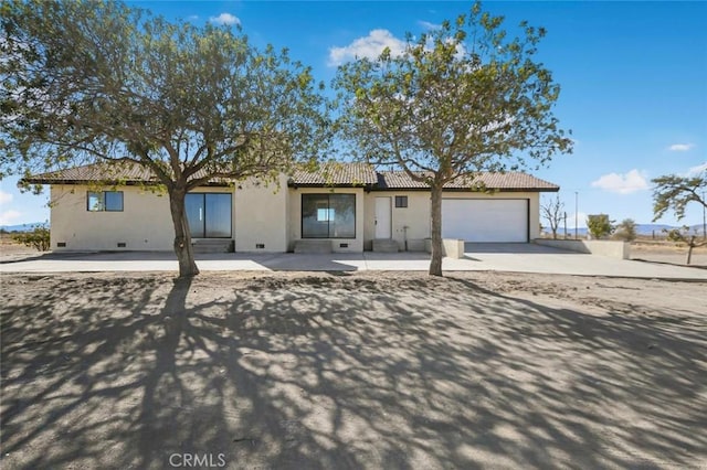 view of front of home featuring a tile roof, stucco siding, concrete driveway, crawl space, and a garage