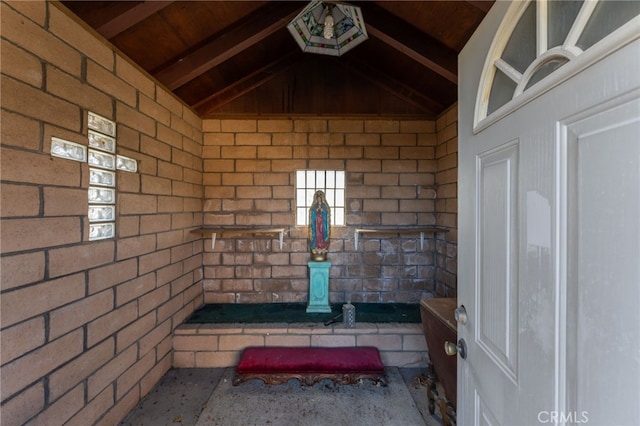 interior space with brick wall and vaulted ceiling