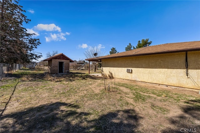 view of yard featuring an outbuilding, fence, and a storage unit