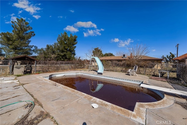 view of pool with a fenced in pool, a patio area, fence, a water slide, and a diving board