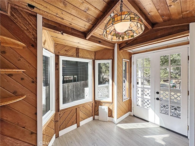 unfurnished sunroom featuring lofted ceiling with beams, wood ceiling, and french doors