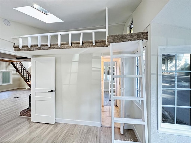 interior space featuring stairway, baseboards, visible vents, and wood finished floors