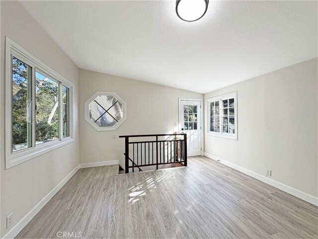 spare room featuring baseboards and wood finished floors