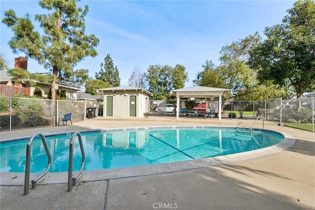 pool with an outbuilding, fence, a gazebo, and a patio