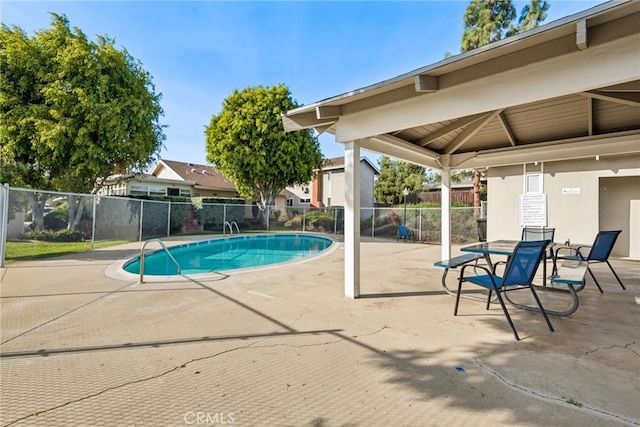 pool with a patio area and fence