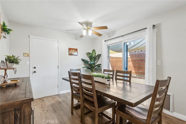 dining space featuring light wood-type flooring, a ceiling fan, and baseboards