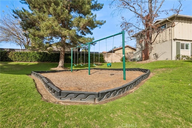 communal playground featuring a yard and fence